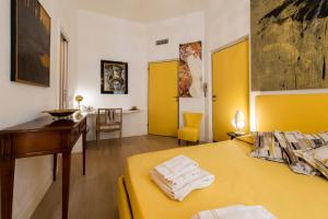 une chambre avec un lit jaune, un bureau et une table dans l'établissement BnButler - Broletto 39 - A few steps to the Duomo and La Scala, à Milan 93 autres photos