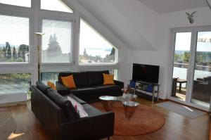 een woonkamer met een bank en een tv bij Ferienwohnung Am Bergle in Überlingen +7 foto's