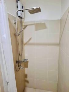 a shower in a bathroom with a glass door at City Escape in Manila
