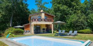 a house with a swimming pool in front of a house at Résidence Château de Salles in Salles