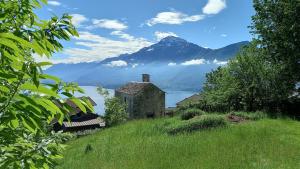 an old house on a hill with a lake and mountains at Lake in Nature in Consiglio di Rumo