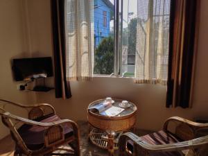 a room with chairs and a table and a window at Breeze Vale Homestay in Shillong