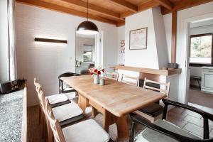 a dining room with a wooden table and chairs at Ferienhaus Tannenblick Rochlitz in Rochlitz +49 photos