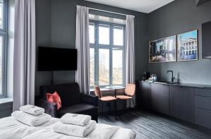 a bedroom with a bed and a chair and a window at Hotel Filip in Oslo