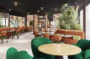 a restaurant with green chairs and tables and tablesktop at Eurostars Rijnhaven in Rotterdam