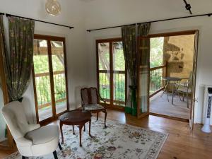 a living room with a table and chairs and windows at ChezLeMoulin Bed and Breakfast in Samouillan