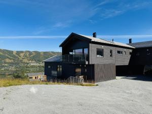 una casa in cima a una collina con un vialetto di Moderne leilighet i Vestlia-Ski in ski out a Geilo