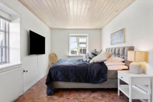 a bedroom with a bed and a television in it at LK2169-Lokken-Sondergade-25-A in Løkken