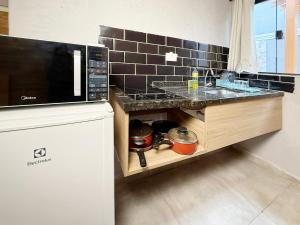 a kitchen with a sink and a counter top at Marmeu Tombo com Hidro Aquecida Privativa in Guarujá +34 photos