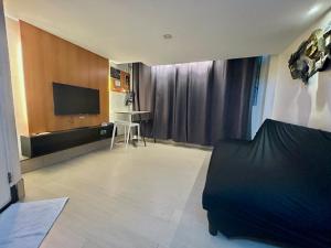 a living room with a bed and a television at Selah Lofts Hotel in Manila +16 photos
