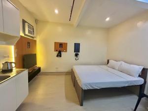 a small room with a bed and a kitchen at Selah Lofts Hotel in Manila