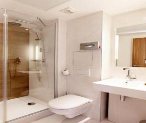 a bathroom with a shower and a toilet and a sink at Hotel Admiral Near Delhi Airport in New Delhi