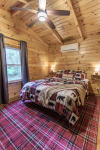 a bedroom with a bed in a log cabin at Copperhead Cabin- Hocking Hills Hot Tub Games in Logan