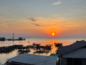 a sunset over a body of water with boats at Motel Gemilang in Karimunjawa