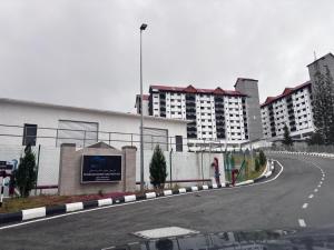 an empty road in a city with tall buildings at The Nest Cameron Homestay in Tanah Rata