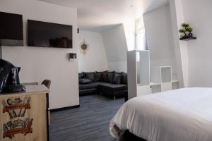 a hotel room with a bed and a couch at SEE - Gare de Marly in Valenciennes