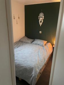 a bedroom with a bed and a clock on the wall at Chalet in de bossen bij Garderen in Putten