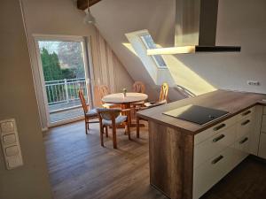 una cucina e una sala da pranzo con tavolo e sedie di Ferienwohnung Vorm Moor a Ostrhauderfehn