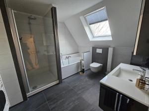 un bagno con doccia, WC e lavandino di Ferienwohnung Vorm Moor a Ostrhauderfehn