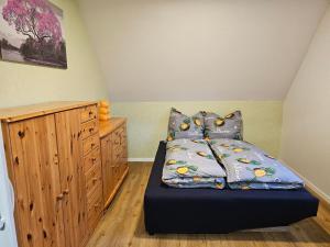 una camera da letto con un letto e un armadio in legno di Ferienwohnung Vorm Moor a Ostrhauderfehn 1 altra foto