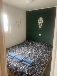 a bedroom with a bed with a skull on the wall at Chalet in de bossen bij Garderen in Putten +4 photos