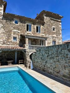 una casa con piscina delante de un edificio en Gite du Chateau, en Éclassan