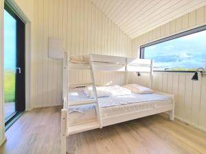 a bunk bed in a room with a window at LK1240-Lokken-Rosavej-13 in Løkken