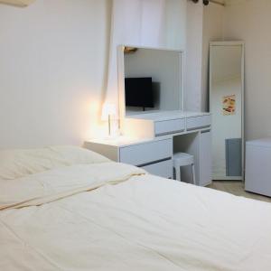a bedroom with two beds and a vanity with a television at Cozy Butter Stay Jeonju in Jeonju