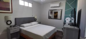 Un dormitorio pequeño con una cama y un espejo. en House of Varz, en Tijuana
