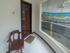 a chair sitting in front of a window at Urbanview Hotel Trisna Srabah in Kalangbret