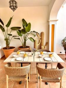 Hacienda el Tarajal في بييغو ذي كوردوبا: غرفة طعام مع طاولة مع كراسي ونباتات