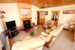 a living room with white furniture and a fireplace at Beezies Self Catering Cottages in Grange
