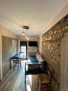 a living room with a stone wall and a table at Vrachos est 1925 in Vráchos