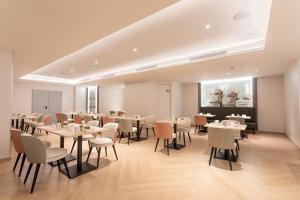 ein Restaurant mit Tischen und Stühlen in einem Raum in der Unterkunft Eurostars Cristal Palace in Barcelona