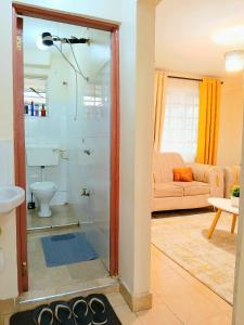 a bathroom with a shower with a glass door at Cosy Homes Eldoret in Eldoret