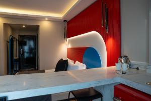 a kitchen with a counter and a red wall at Lucky Monkey Midi Hotel in Antalya +59 photos