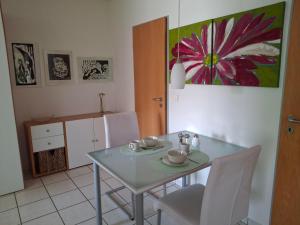 a dining room with a glass table and white chairs at Hofmann's Ferienwohnung in Bad Neuenahr-Ahrweiler