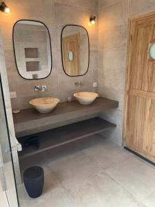 une salle de bain avec deux lavabos et deux miroirs dans l'établissement VILLA de Standing, 10 personnes, Piscine, Spa à 200m des plages, à Brignogan-Plage