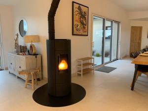 - un salon avec un poêle à bois dans l'établissement VILLA de Standing, 10 personnes, Piscine, Spa à 200m des plages, à Brignogan-Plage