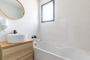 ein Badezimmer mit Waschbecken, Badewanne und Spiegel in der Unterkunft La Beaumière #Piscine#Garage in Ceyrat + 12 Fotos