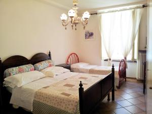 1 dormitorio con 2 camas y lámpara de araña en Casa Dolce Chiara, en Asís