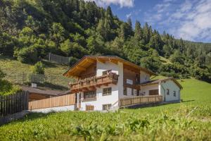 a house in the mountains with a balcony at Hieser's apartments in Neustift im Stubaital