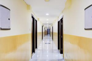 加尔各答Hotel O Kyd Guest House的建筑中空无一人的走廊,设有门和天花板