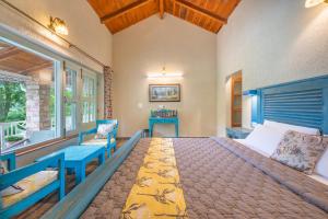a bedroom with a blue bed and a window at Echor Malusara Lakeview Retreat Bhimtal in Bhīm Tāl +63 photos