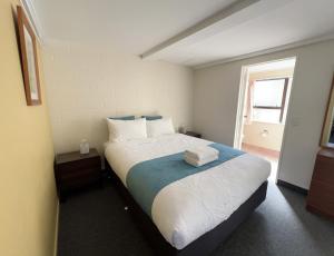 a bedroom with a large bed with towels on it at Mountain View Motel in Taupo