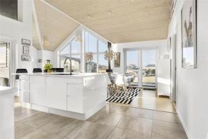 a kitchen with white cabinets and a table and chairs at LK536-Lokken-Ternevej-33 in Løkken