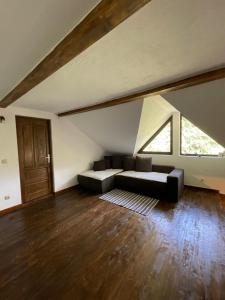 a living room with a couch in a attic at Casuța cu târnaț in Colibiţa
