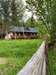 a wooden fence in front of a house at Casuța cu târnaț in Colibiţa