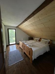 a bedroom with two beds and a large window at Casuța cu târnaț in Colibiţa