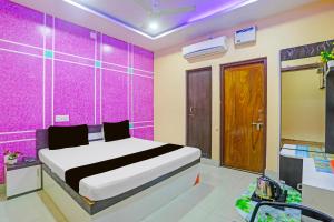a bedroom with a bed and a purple wall at Hotel O Chandia Palace Kendrapara Railway Station in Kendrāparha